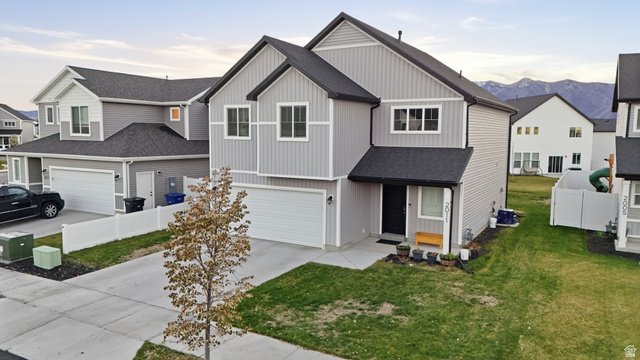 2011 Wren Circle Logan, UT 84339 - Photo 2 of 20 View of front of property featuring concrete driveway, a shingled roof, a residential view, board and batten siding, and a garage