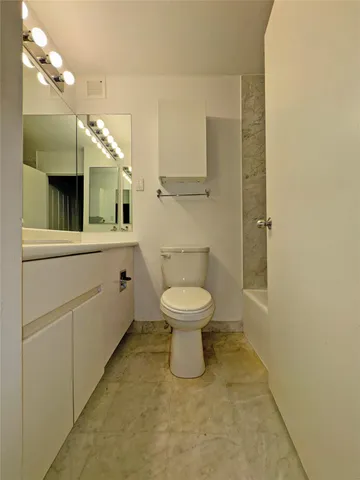 a bathroom with a toilet a sink and mirror
