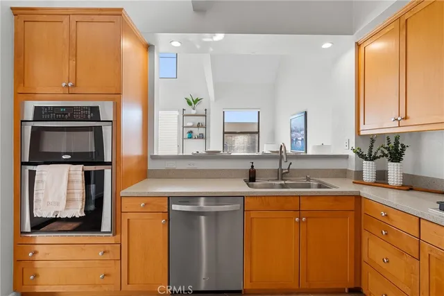 a kitchen with stainless steel appliances granite countertop a refrigerator a sink and white cabinets
