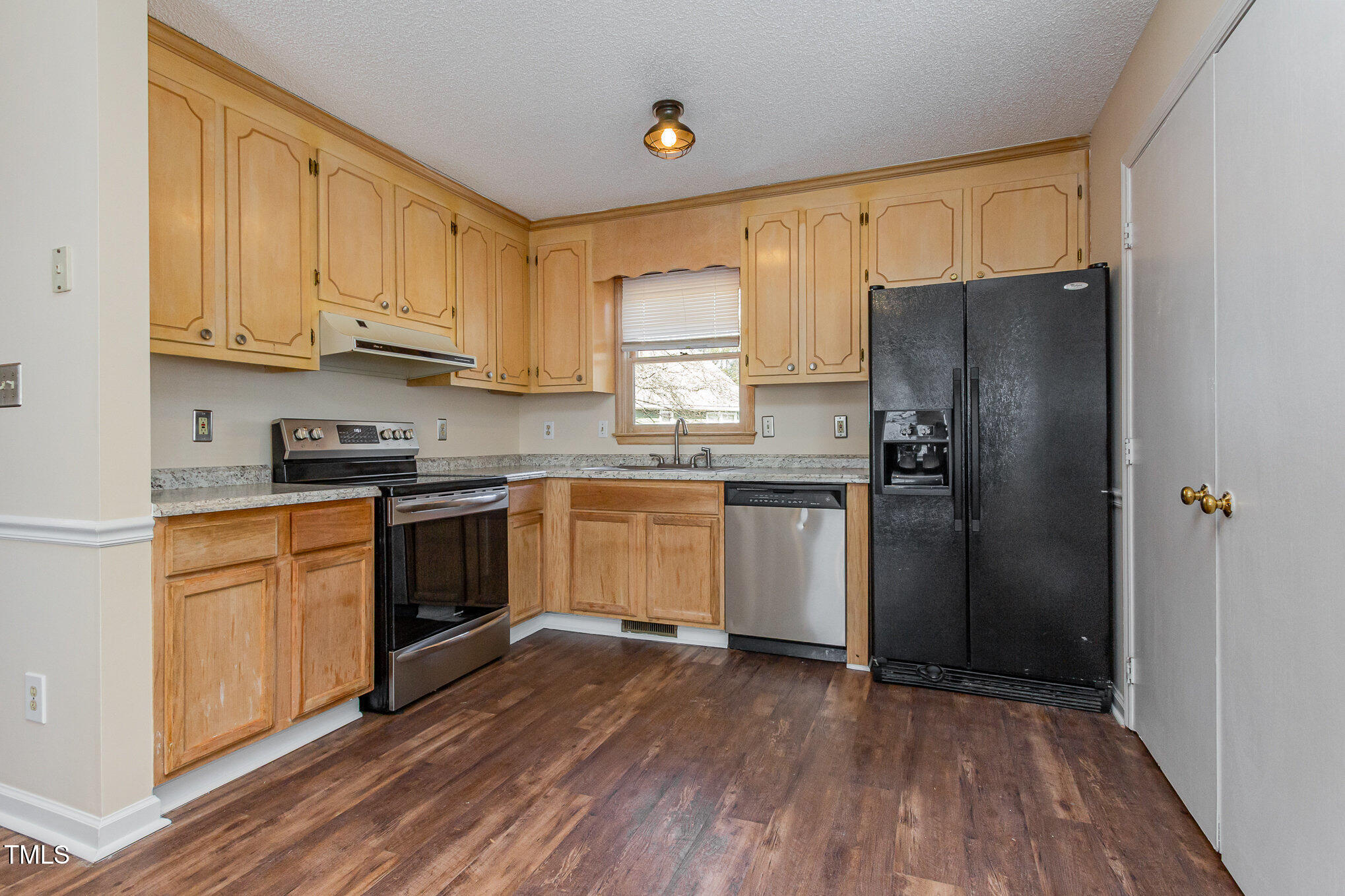3332 Castlegate Drive Raleigh, NC 27616 - Photo 11 of 22 a kitchen with granite countertop a refrigerator oven a sink dishwasher and wooden cabinets with wooden floor