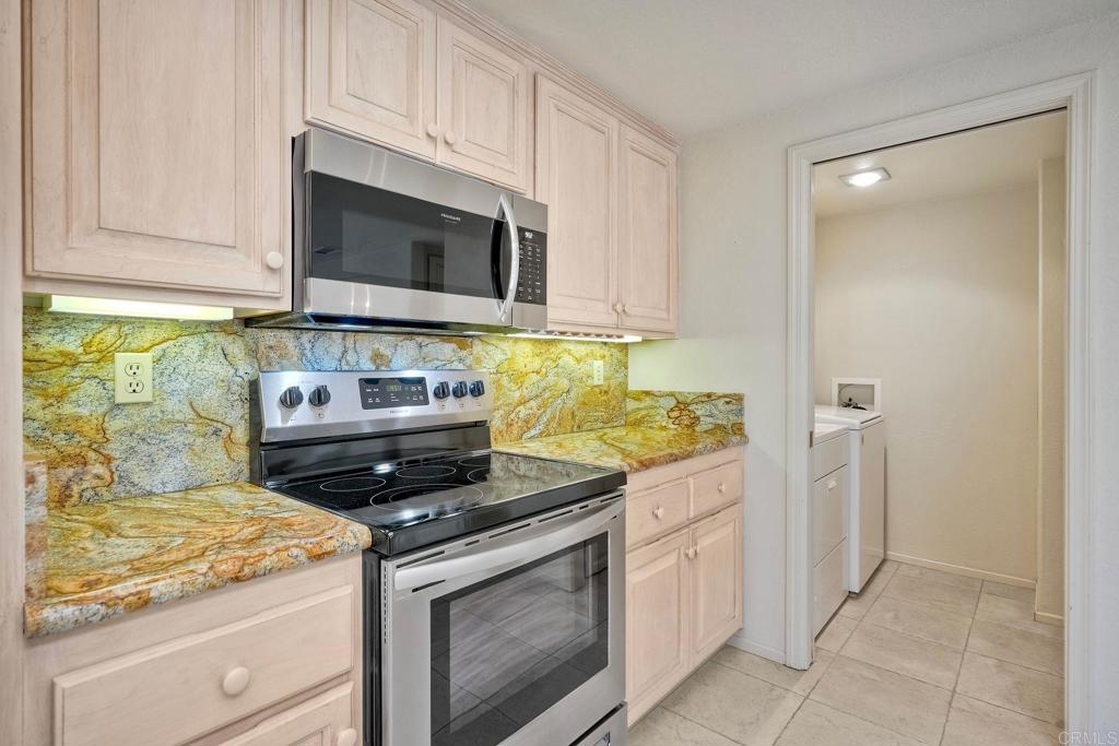 4760 Galicia Way Oceanside, CA 92056 - Photo 16 of 56 a kitchen with stainless steel appliances granite countertop white cabinets and a stove