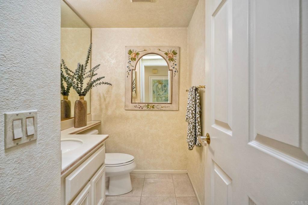 4760 Galicia Way Oceanside, CA 92056 - Photo 17 of 56 a bathroom with a toilet a sink and mirror