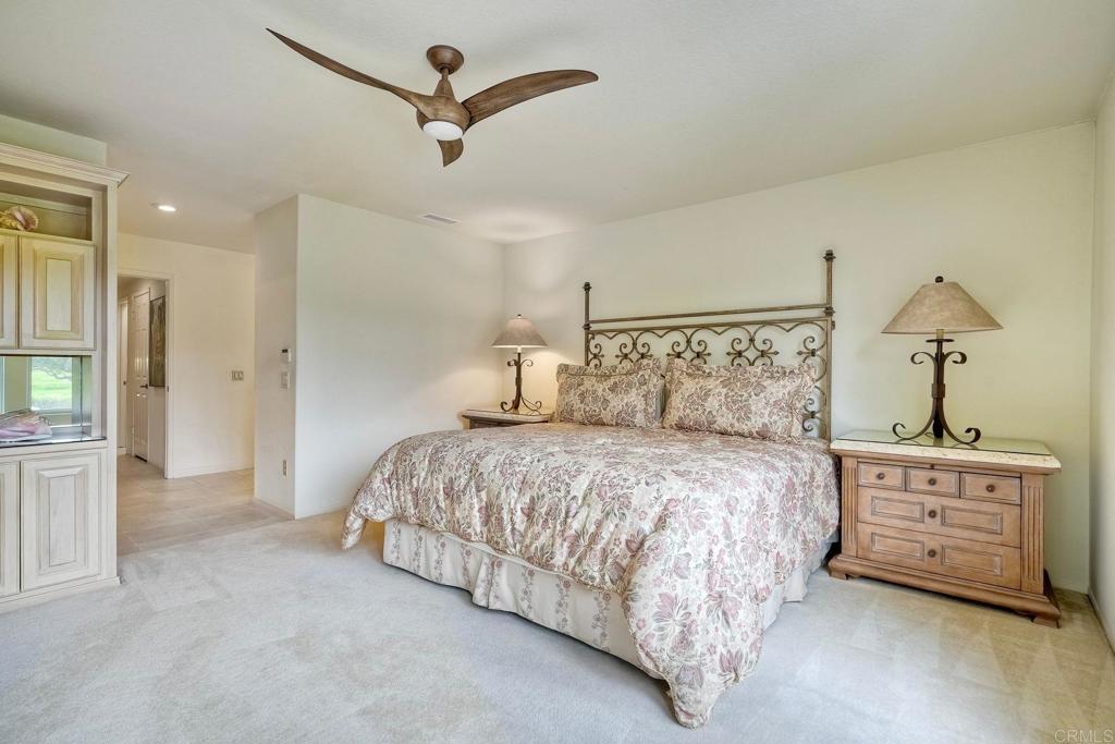 4760 Galicia Way Oceanside, CA 92056 - Photo 18 of 56 a bedroom with a bed and a chandelier