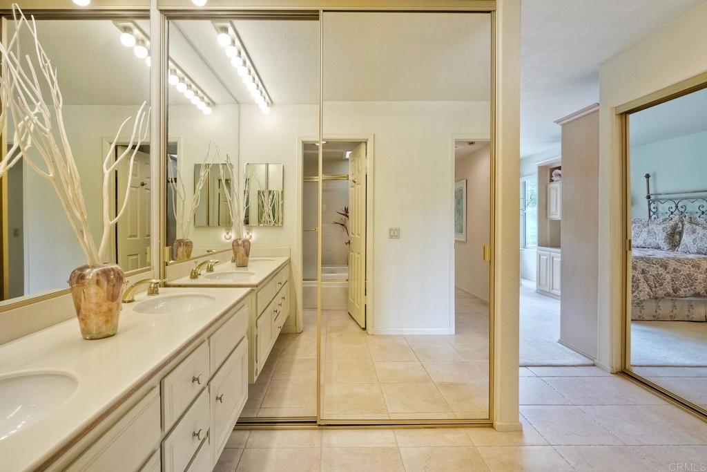 4760 Galicia Way Oceanside, CA 92056 - Photo 21 of 56 a bathroom with a tub sink and mirror