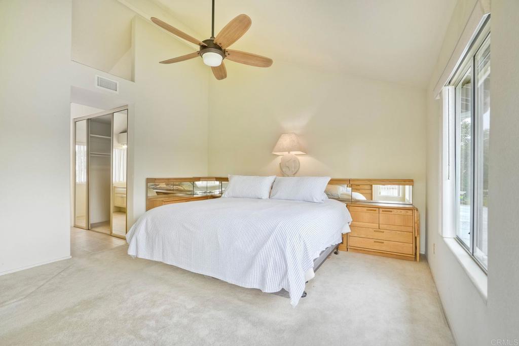 4760 Galicia Way Oceanside, CA 92056 - Photo 29 of 56 a bedroom with a bed and a chandelier