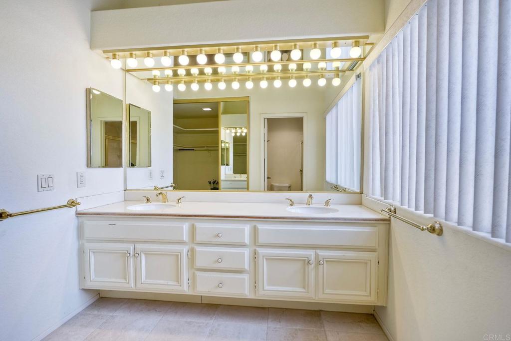 4760 Galicia Way Oceanside, CA 92056 - Photo 32 of 56 a bathroom with a double vanity sink and a mirror
