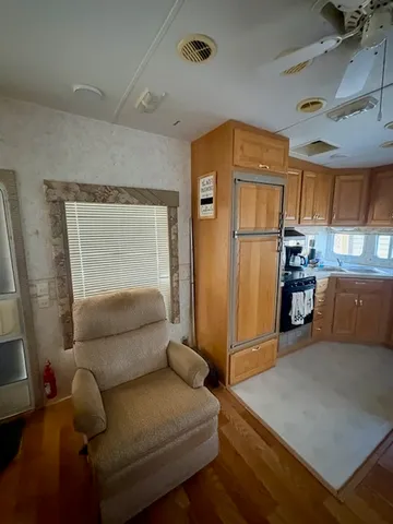 a living room with furniture and a refrigerator
