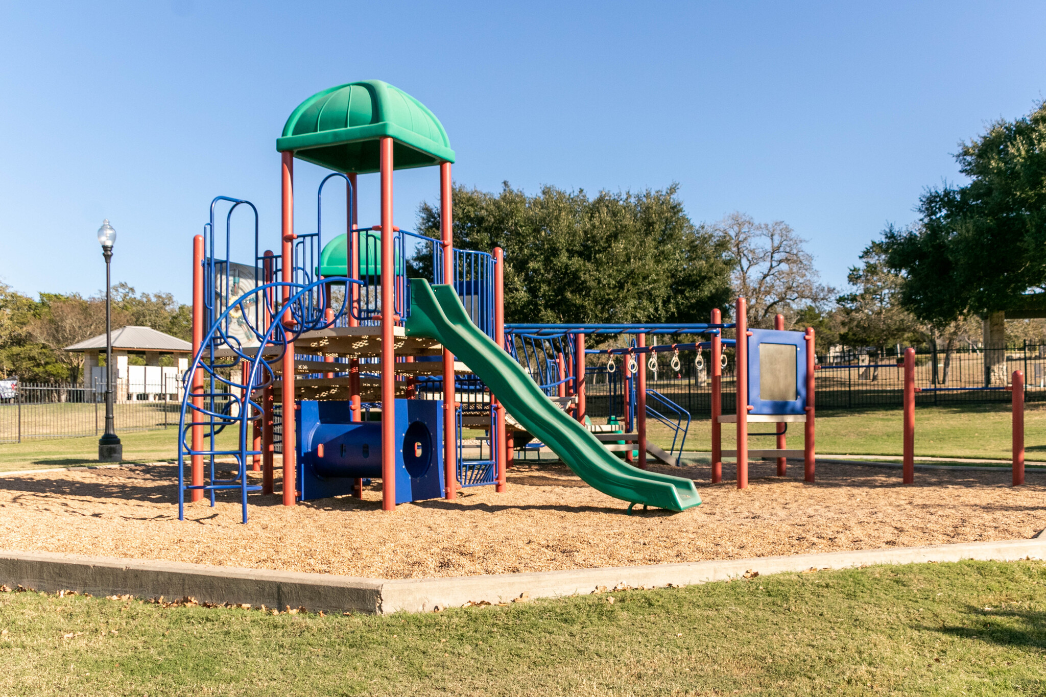 165 Maddy Way Bastrop, TX 78602 - Photo 17 of 23 a view of a park with swings and slides