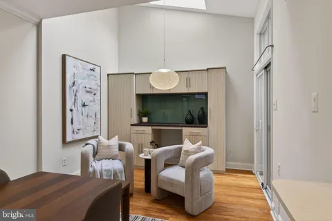 a living room with furniture a flat screen tv and wall paintings
