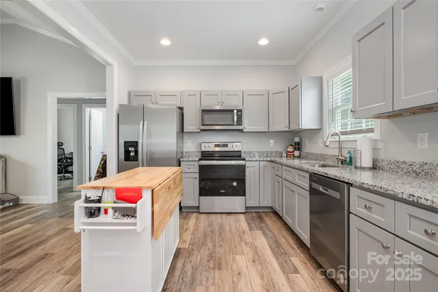 a kitchen with a sink and wooden floor