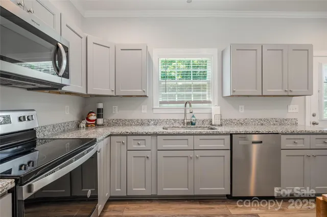 a kitchen with stainless steel appliances granite countertop a sink stove and cabinets