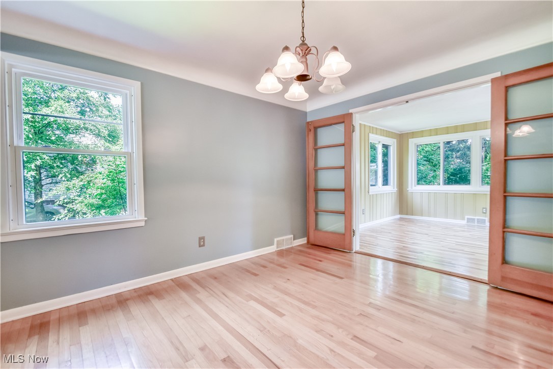 2607 Ashurst Road University Heights, OH 44118 - Photo 15 of 39 Empty room featuring a chandelier, healthy amount of natural light, and wood finished floors