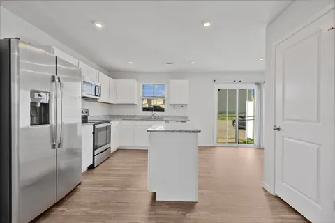 a kitchen with stainless steel appliances granite countertop a refrigerator and a sink