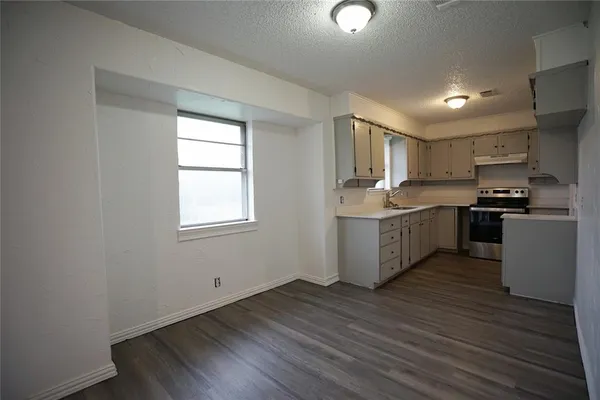 a kitchen with stainless steel appliances granite countertop a stove a sink dishwasher and a refrigerator
