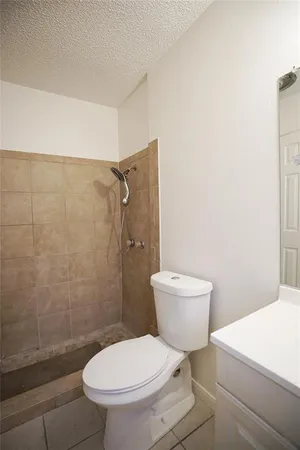a white toilet sitting next to a bathroom sink and a shower