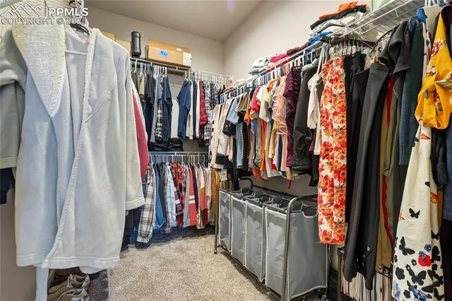a view of walk in closet with clothes