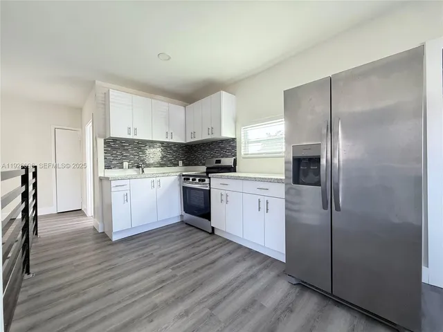 a kitchen with white cabinets and white appliances
