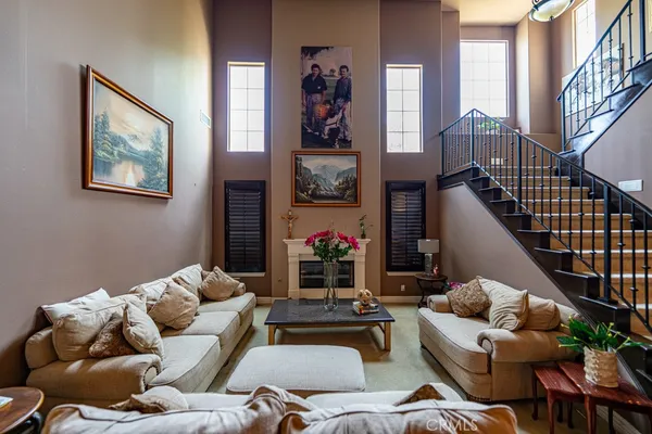 a living room with furniture chess board and stairs