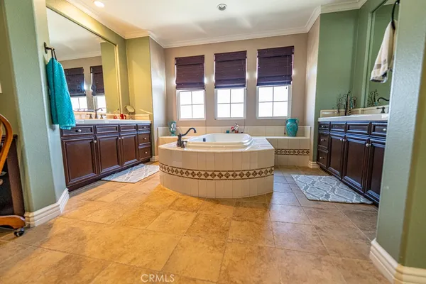 a spacious bathroom with a tub sink and mirror