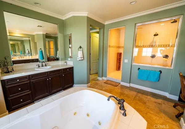 a spacious bathroom with a tub sink and mirror