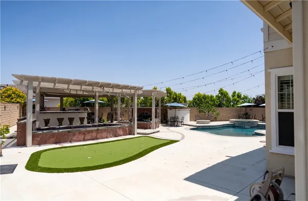 a view of a swimming pool with lawn chairs under an umbrella