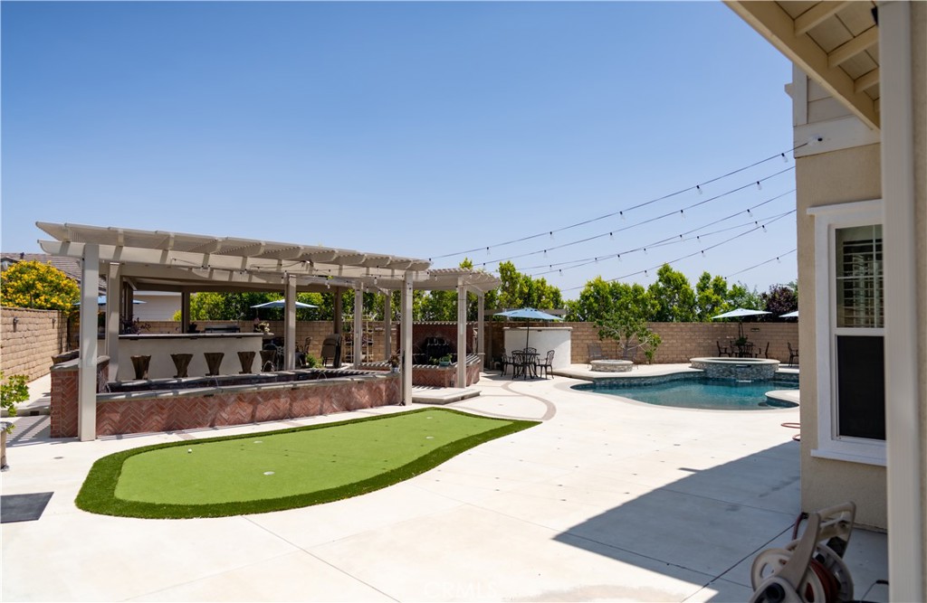 5075 Branding Iron Place Rancho Cucamonga, CA 91739 - Photo 28 of 41 a view of a swimming pool with lawn chairs under an umbrella