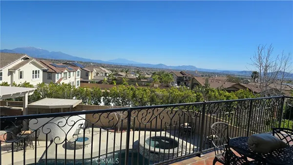 a view of a balcony with wooden chairs and floor to ceiling window