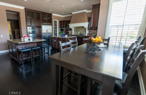 a living room with stainless steel appliances a table chairs and a table