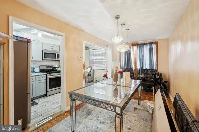 a kitchen with a refrigerator a stove and a dining table