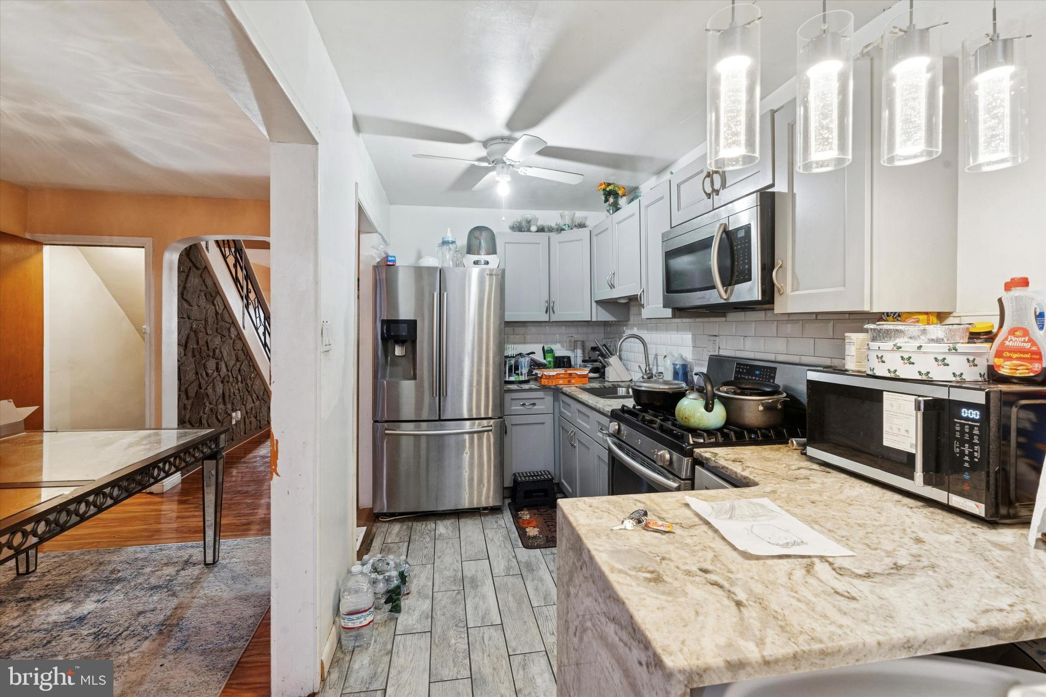 213 East Claremont Road Philadelphia, PA 19120 - Photo 8 of 25 a kitchen with stainless steel appliances granite countertop a refrigerator stove microwave and sink