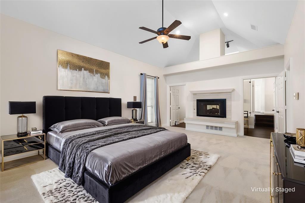 609 Seville Road Denton, TX 76205 - Photo 19 of 39 Oversized Primary Suite downstairs with carpet, high ceilings, fireplace and en-suite bath. Virtually Staged.