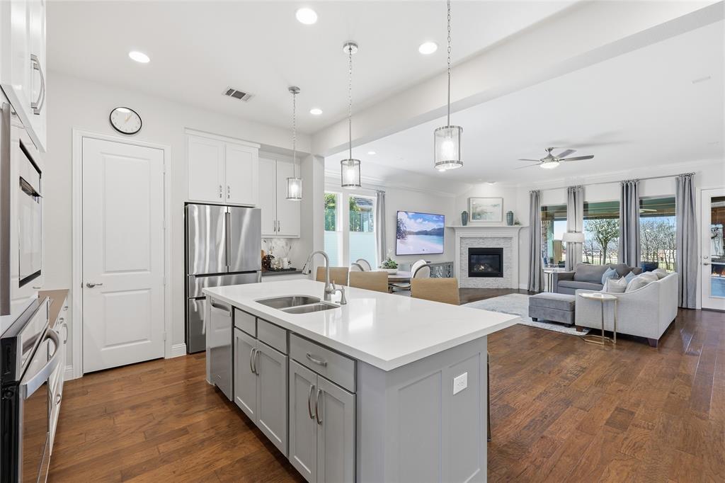 1601 Twistleaf Road Flower Mound, TX 76226 - Photo 20 of 39 a kitchen with sink a refrigerator and chairs