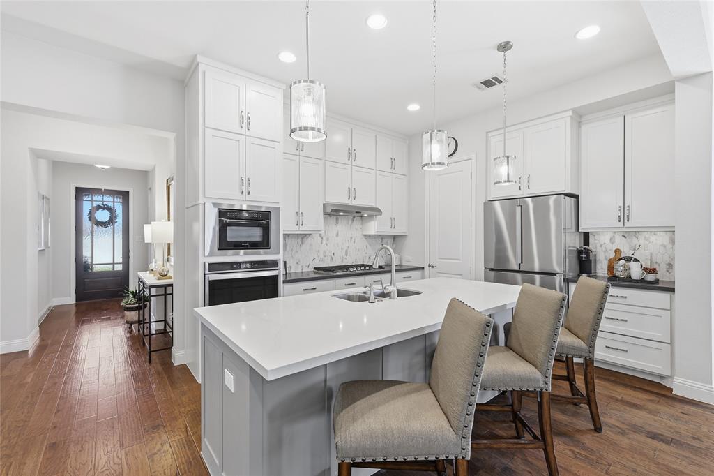 1601 Twistleaf Road Flower Mound, TX 76226 - Photo 21 of 39 a kitchen with a table chairs refrigerator and cabinets