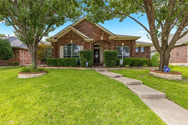 a front view of a house with yard and green space