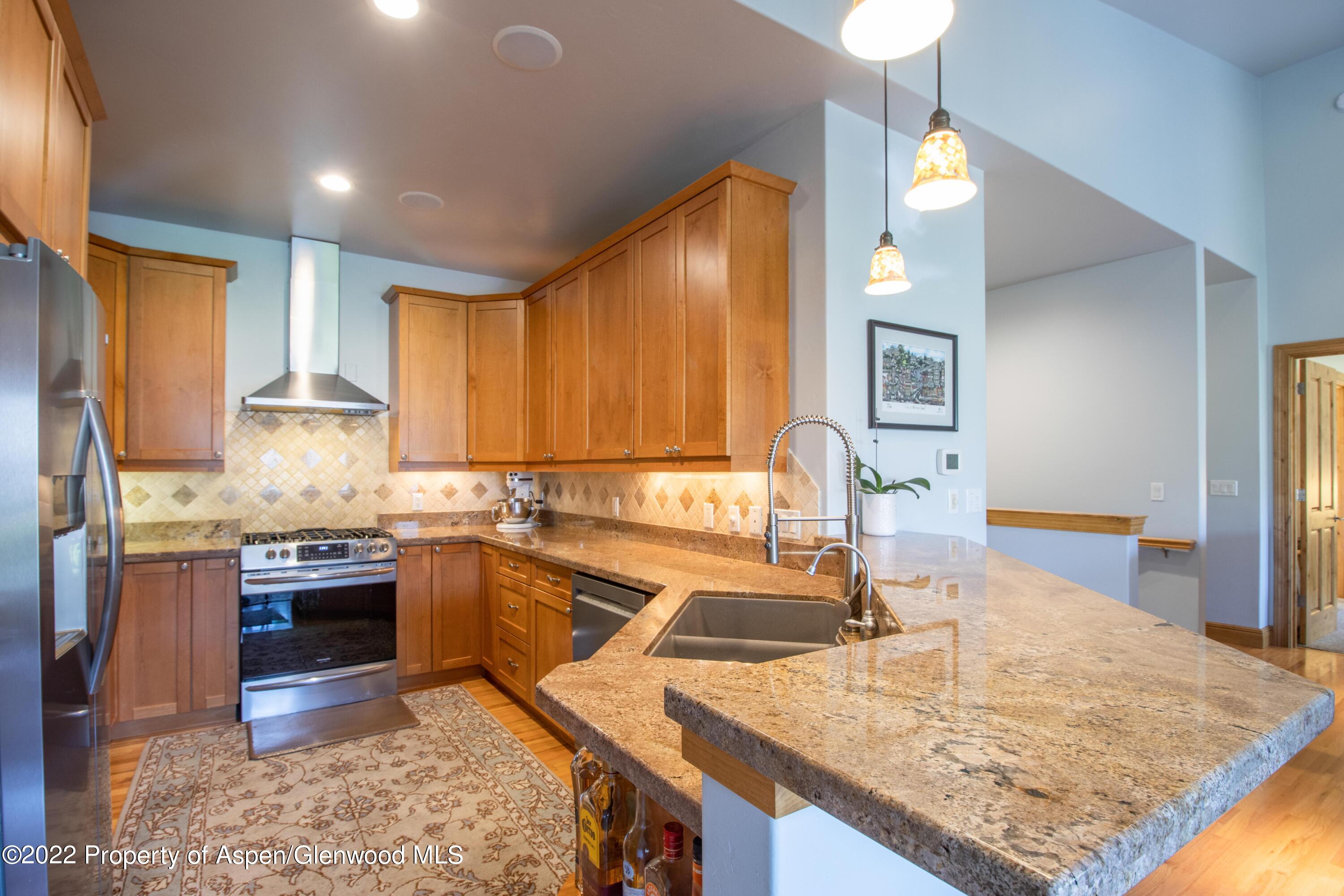 323 Faas Ranch Road New Castle, CO 81647 - Photo 11 of 22 a kitchen with kitchen island granite countertop a sink stove and cabinets