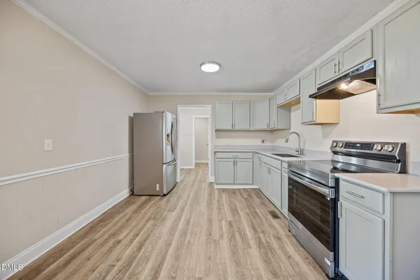 a kitchen with a sink a counter top space stainless steel appliances and cabinets
