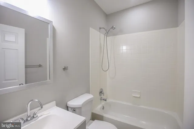 a bedroom with a bed painting on wall and a potted plant