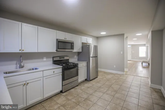 a kitchen with white cabinets and refrigerator