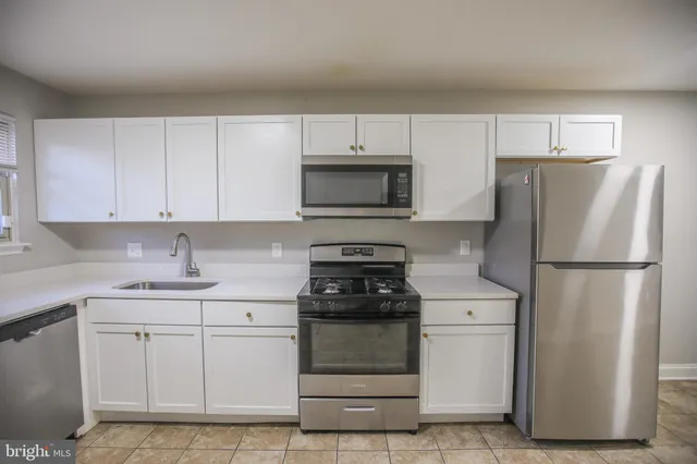 a kitchen with a refrigerator sink and cabinets