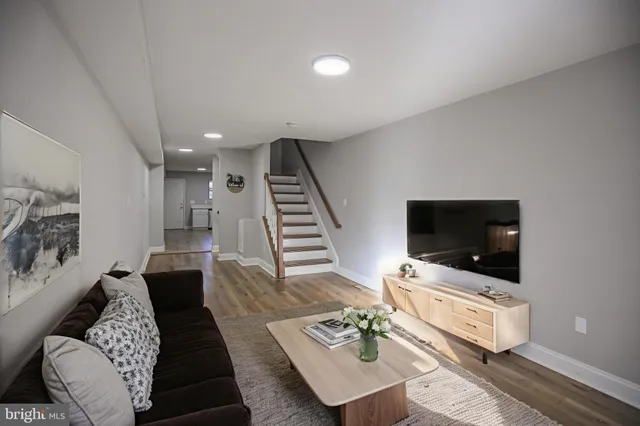a view of a hallway with stairs and wooden floor