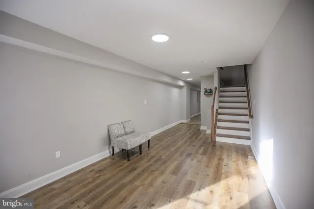 a hallway with stairs and wooden floor