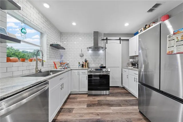 a kitchen with stainless steel appliances granite countertop a refrigerator sink and stove