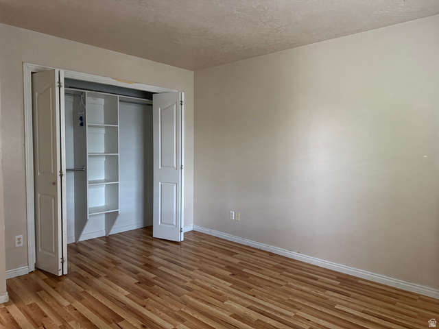 44 Wapiti Loop Hyrum, UT 84319 - Photo 11 of 18 Room featuring wood-finish flooring, light-toned walls, and a closet with bifold doors