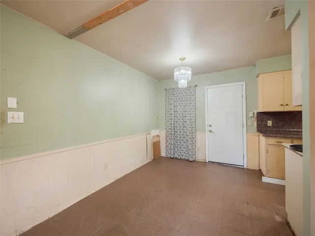 a view of empty room with kitchen and window