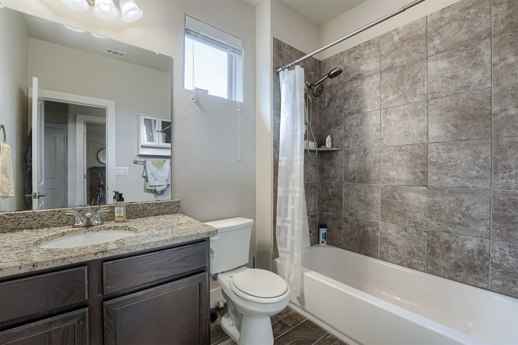 418 High Tech Drive Georgetown, TX 78626 - Photo 18 of 34 Bathroom featuring a vanity with a granite-look countertop, integrated sink, and dark wood-finish cabinetry