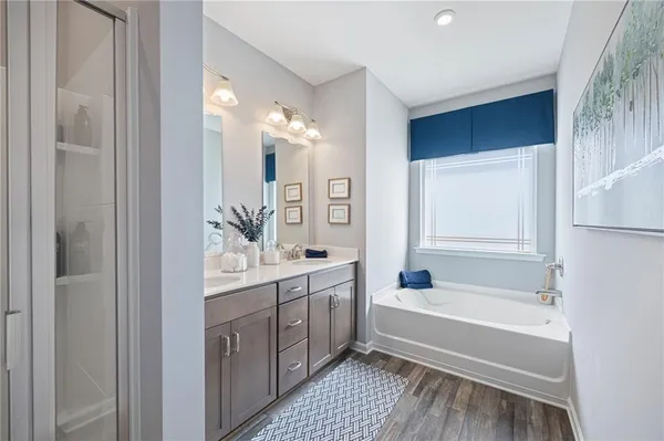 a spacious bathroom with a tub sink and mirror