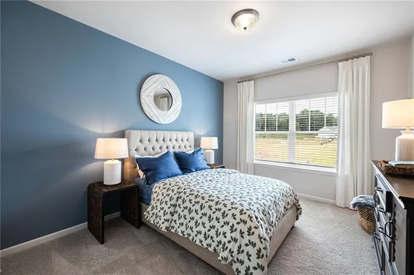 a bedroom with a bed and a lamp next to a window