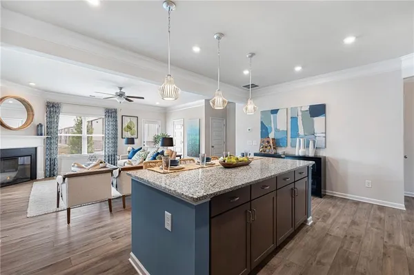 a kitchen with a counter top space a sink appliances and a living room view