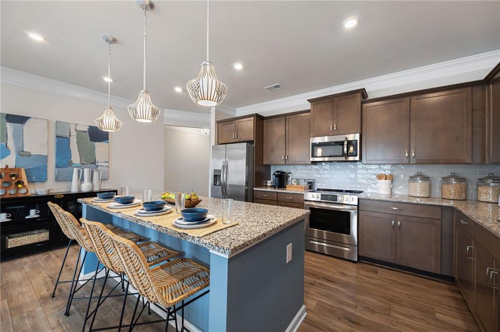 70 Pinnacle Way Jasper, GA 30143 - Photo 8 of 20 a kitchen with stainless steel appliances granite countertop a sink a stove a kitchen island with chairs and white cabinets