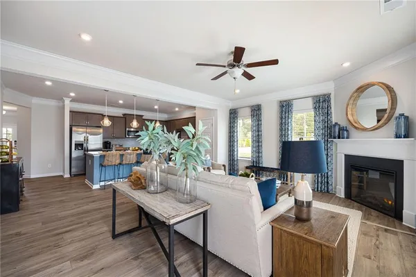 a living room with furniture a fireplace and a ceiling fan